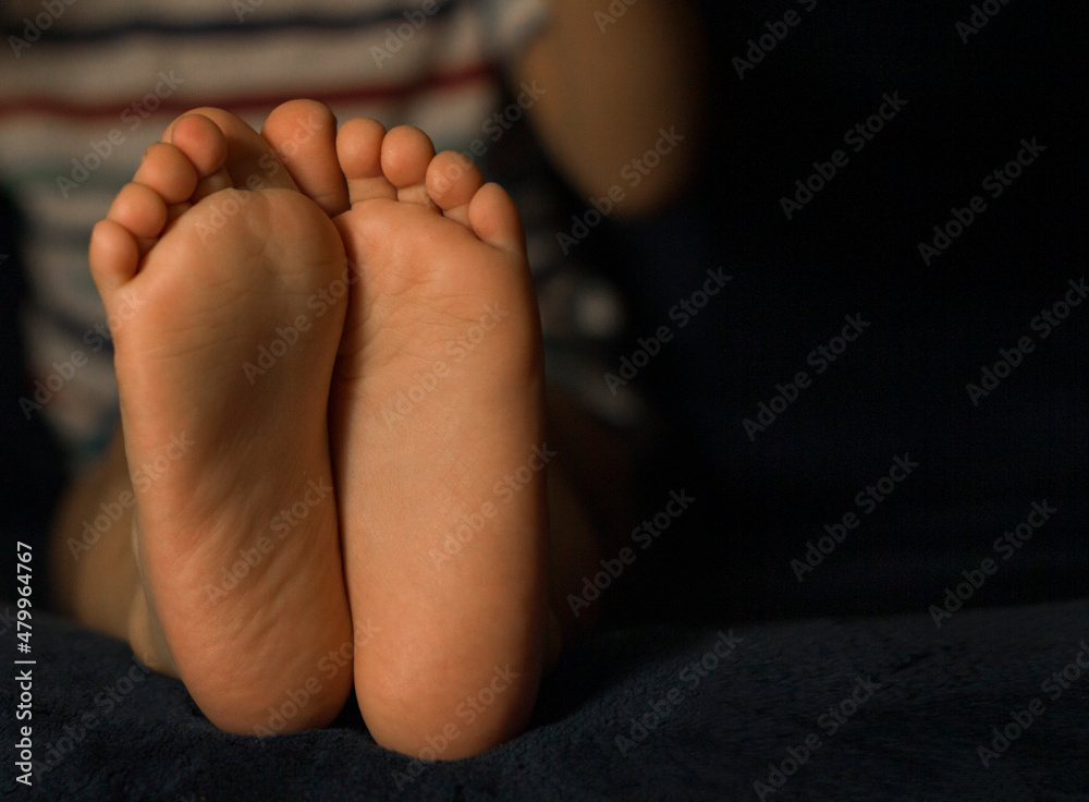 child's feet on a dark background child's feet on a dark background