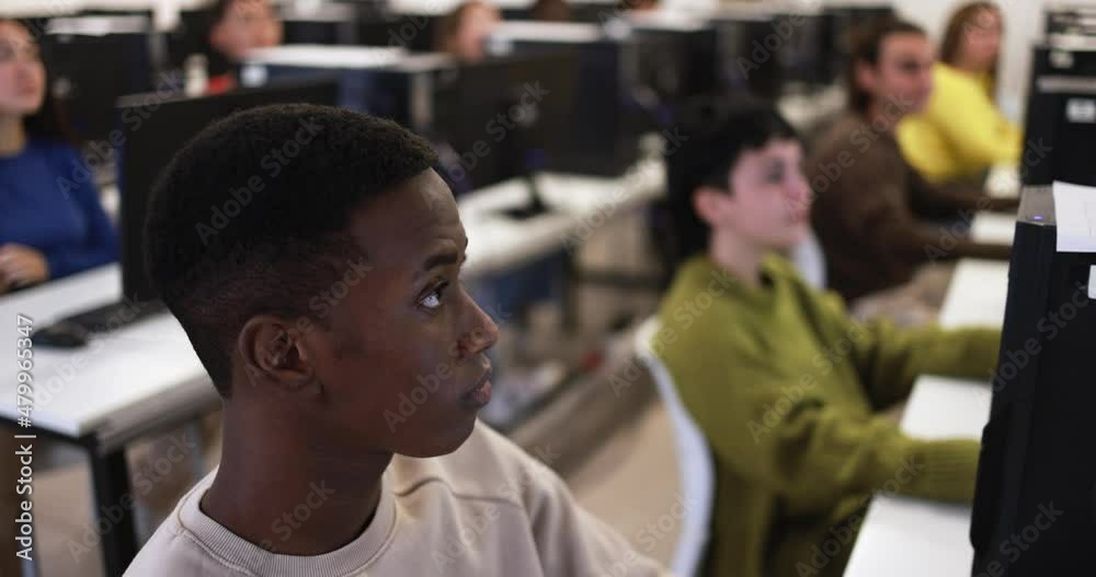 Young multiracial people using computers inside school classroom at university