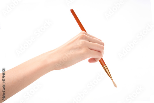 Female hand with brush on white background. Hand with a brush