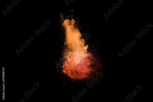 Closeup of orange dust particle splash isolated on black background. Powder explosion.