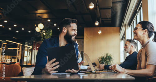 Co-workers smiling at each other in a co-working space photo