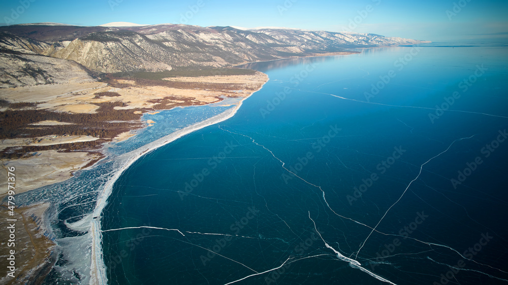 Frozen Lake Baikal in January. Transparent ice. Winter trip. Aerial photography. 