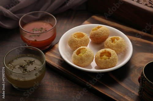 Indian Food Snacks Gol Gappe or Pani Puri or Puchka Water Balls in a White Plate with Flavoured Water