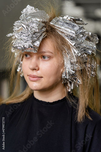 Foil on models hair. Trendy hair lightening using shatush technique. photo