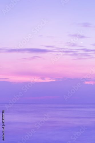 Beautiful long exposure seascape of smooth wavy sea and clound. Pink horizon with first sunset sky. verical photo.