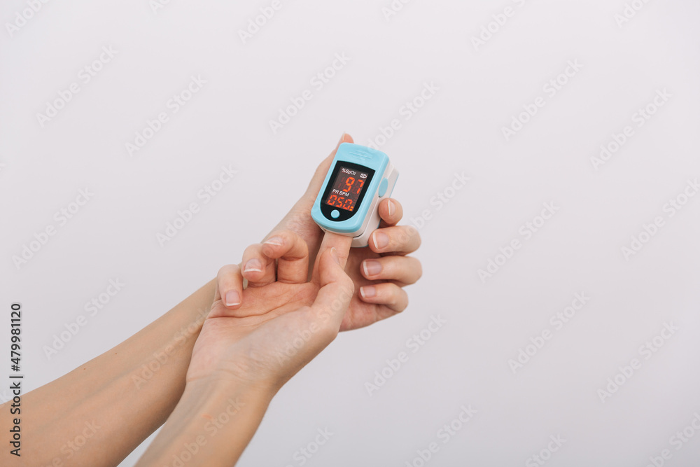 Pulse oximeter with hand of doctor isolated on white. The concept of portable digital device to measure person's oxygen saturation. Measuring oxygen saturation, pulse rate and oxygen levels. Pulse oximeter with hand of doctor isolated on white. The concept of portable digital device to measure person's oxygen saturation. Measuring oxygen saturation, pulse rate and oxygen levels.