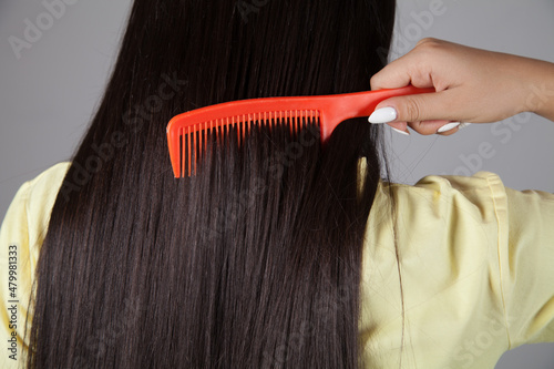 Woman combing her hair. Beautiful hair concept.