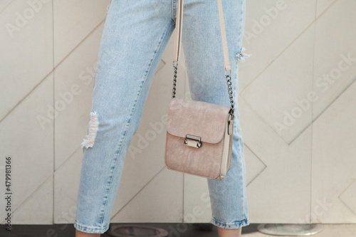 Young woman holding luxury handbag, and wearing trendy outfit. Fashion concept.