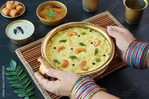 Ven Pongal Khara Pongal Sambar coconut chutney woman hand serving Indian breakfast food Tamil Nadu festival Pongal Sankranti Diwali spicy pongal using rice lentil semolina rava South India Sri Lanka