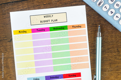 Weekly budget plan form and calculator with pen. photo