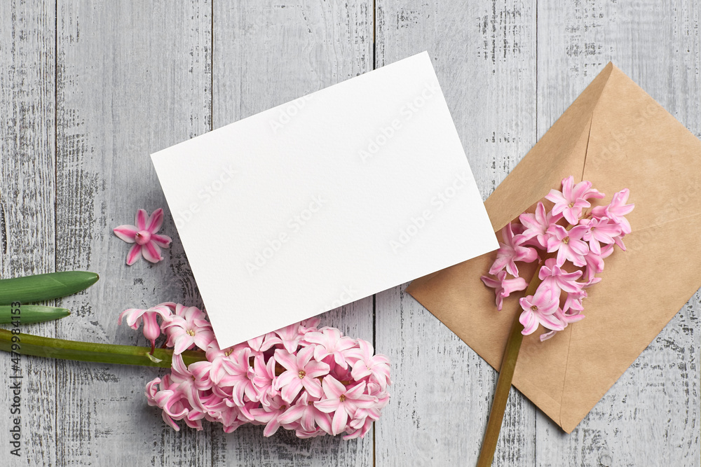 Invitation or greeting card mockup with envelope and hyacinth flowers on wooden background