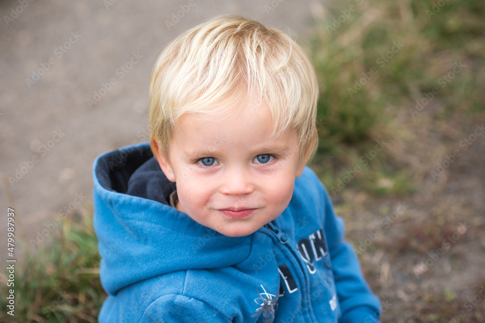 Portrait of a little caucasian child. Smiling small blond kid with blue eyes. Top view. Portrait of a little caucasian child. Smiling small blond kid with blue eyes. Top view.