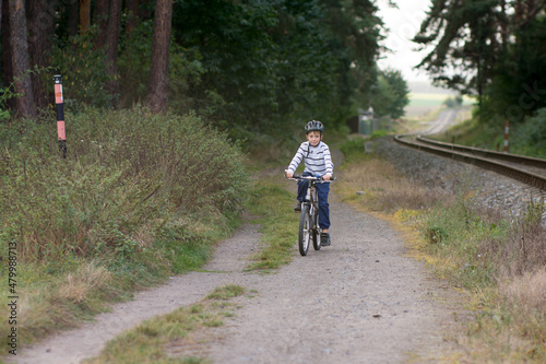 Little caucasian boy ride a bike. Safe sport with helmet protection.