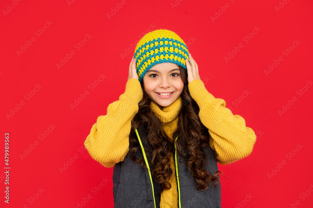cheerful teen girl on red background. portrait of child wearing warm clothes. cheerful teen girl on red background. portrait of child wearing warm clothes.