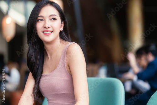 casual smiling of asian female adult woman portrait candid of attractive asian female casual relax positive emotion sit and joy peaceful moment at cafe restaurant toothy smile look out of window day