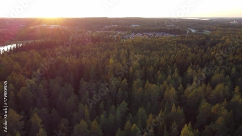 Drone shot of the sunset over a coniferous forest and the town of Kajaani in central Finland's Kainuu region. Autumn Finnish nature. Exploring the airspace photo