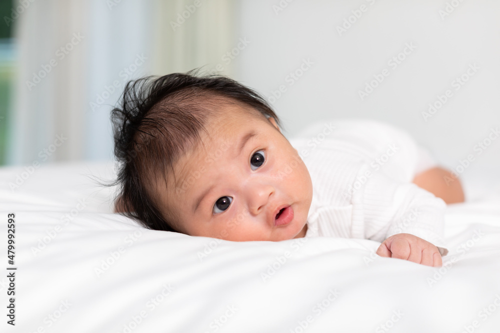 Newborn baby 3 month laying on stomach developing neck control .tummy time for strengthen baby neck and shoulder muscles.Cute infant lying crawling on white bed happiness and fun.Tummy Time Concept Newborn baby 3 month laying on stomach developing neck control .tummy time for strengthen baby neck and shoulder muscles.Cute infant lying crawling on white bed happiness and fun.Tummy Time Concept