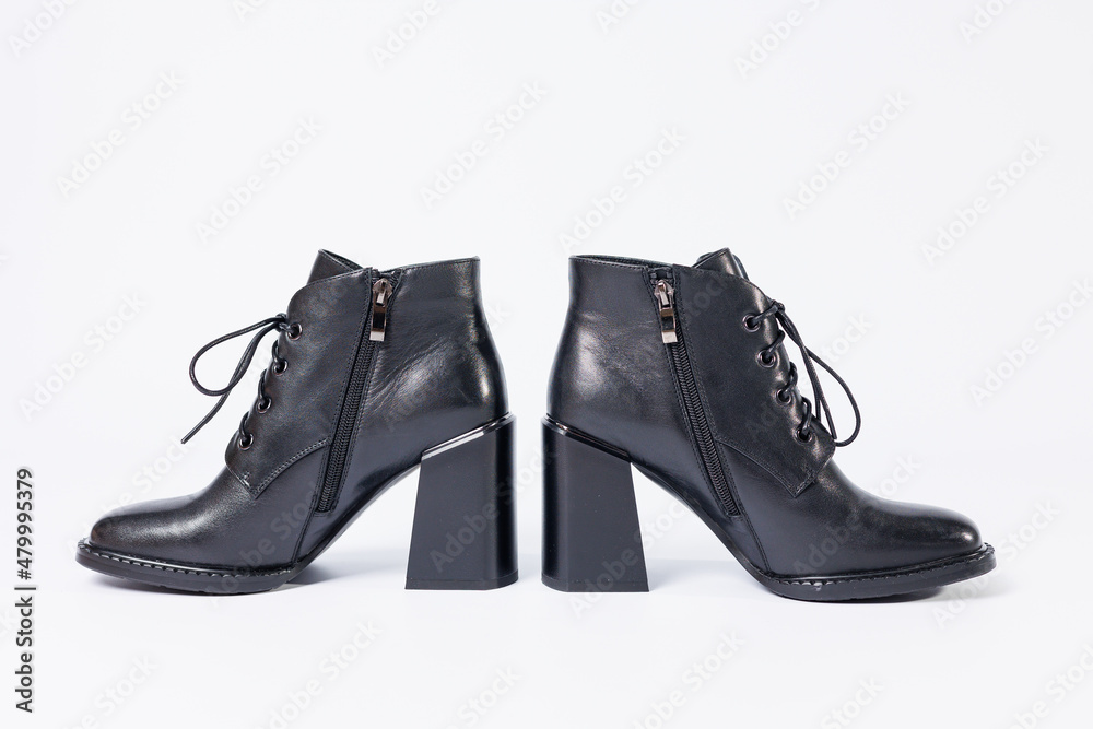 Women's boots with black genuine leather on heels isolated on a white background. photo from the side, diagonally and foreshortened from behind. Women's shoe collection 2022 Women's boots with black genuine leather on heels isolated on a white background. photo from the side, diagonally and foreshortened from behind. Women's shoe collection 2022