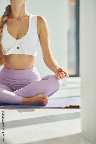 Yoga pose. Woman in sportive clothes is indoors
