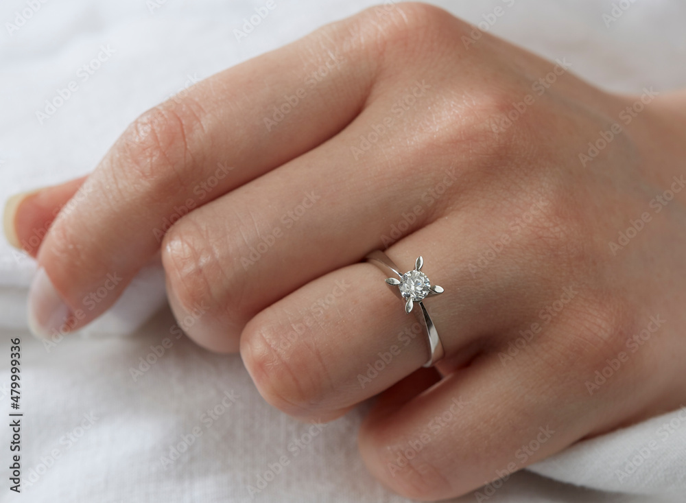 Jewelry background. Diamond ring on woman hand