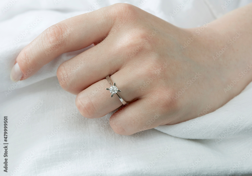 Jewelry background. Diamond ring on woman hand