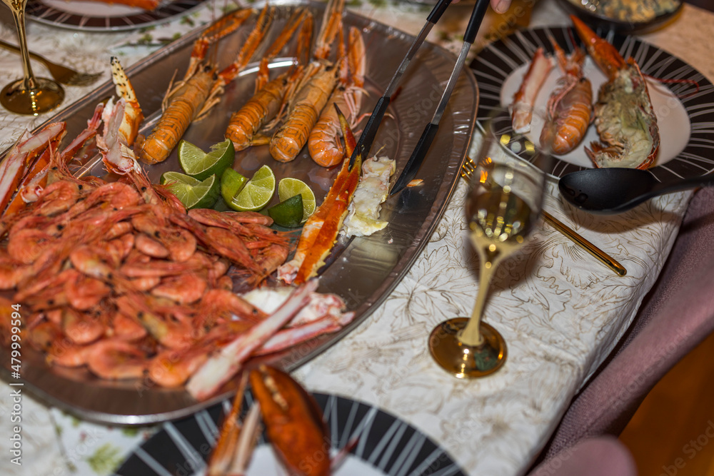 Close up view of a man who lays out seafood dishes in plates on table. Sweden. Close up view of a man who lays out seafood dishes in plates on table. Sweden.