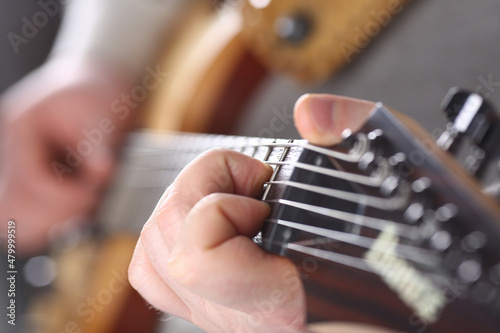 Male hands holding and playing wooden guitar
