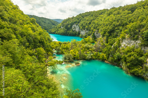 Last sunlight lights up the pure water waterfall on Plitvice National Park. Colorful spring panorama of green forest with blue lake. Great countryside view of Croatia, Europe.