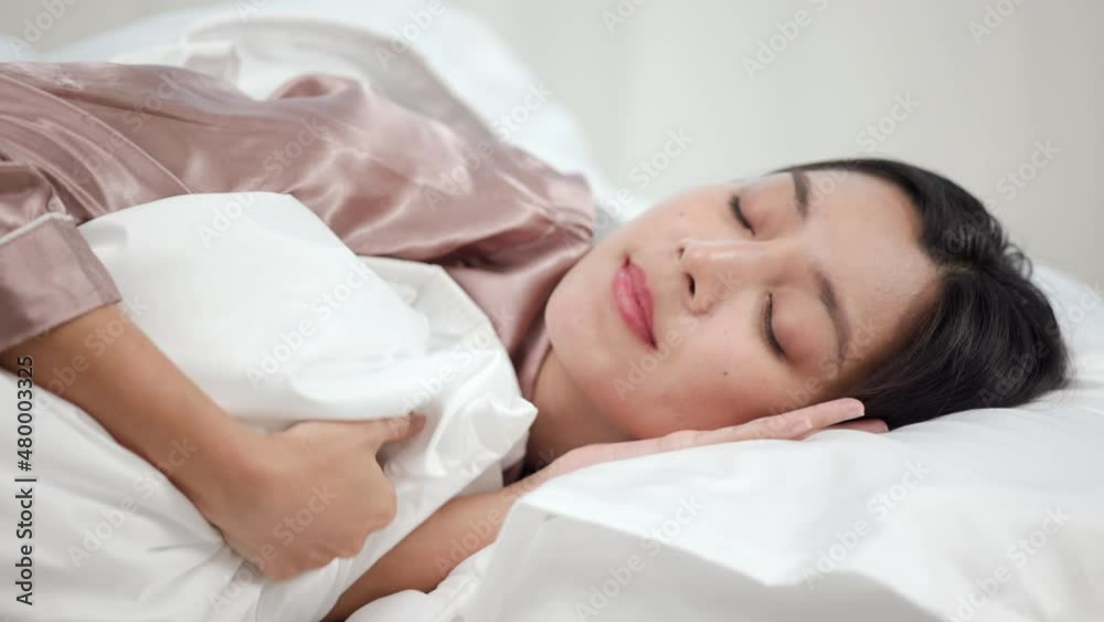 Beautiful asian woman lying in the bed . Young woman sleeping well in comfortable cozy fresh bed on soft pillow white linen. Morning in the bedroom. Health and rest concept. Beautiful asian woman lying in the bed . Young woman sleeping well in comfortable cozy fresh bed on soft pillow white linen. Morning in the bedroom. Health and rest concept.