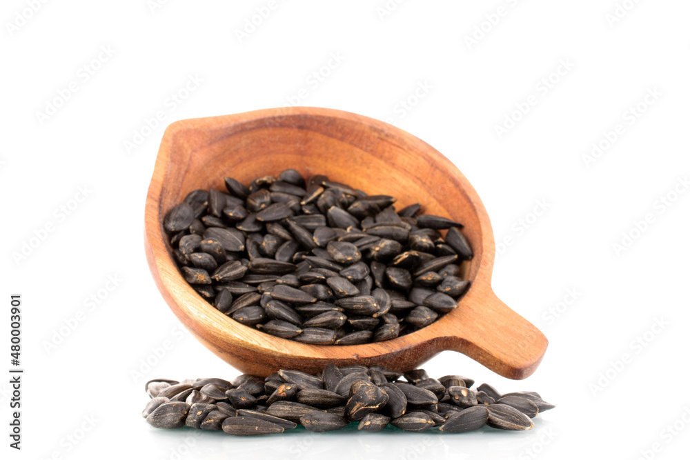 Many fragrant sunflower seeds with a wooden cup, close-up, isolated on white.