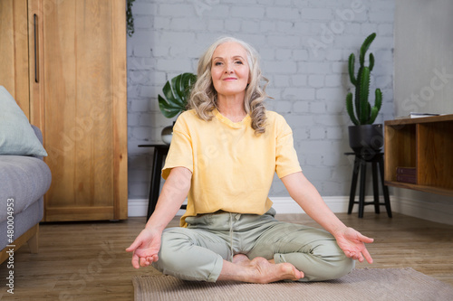elderly woman  is doing stretches or yoga at home. healthy lifestyle. sports at home