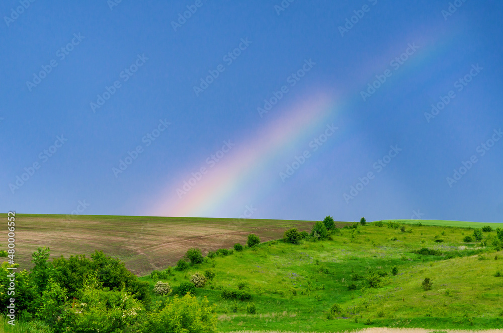 Very beautiful gentle spring photo. Rainbow on the field after rain. Beautiful rainbow wallpaper. Photo for design, inspiration. Very beautiful gentle spring photo. Rainbow on the field after rain. Beautiful rainbow wallpaper. Photo for design, inspiration.