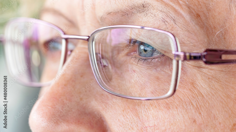 Sad senior woman's eyes with glasses macro photography. Close-up of wrinkles on the mature skin of the face. The concept of vision correction for eye diseases. Detailed image of eyes with glasses. Sad senior woman's eyes with glasses macro photography. Close-up of wrinkles on the mature skin of the face. The concept of vision correction for eye diseases. Detailed image of eyes with glasses.