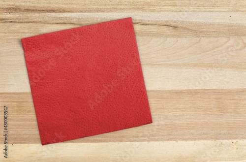 Red textile napkin. Folded decorative kitchen cotton towel.