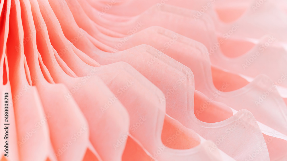 Abstract coral background with perspective macro photography. Pink background with geometric shapes. Detail of a paper fan close-up.