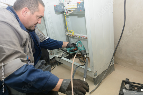 Process of installing 0.4 kilovolt cable sleeve. An electrical engineer connects the electrical cable to control cabinet