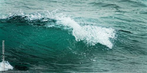 Close up of a wave. Blue clear water splash, ocean background.