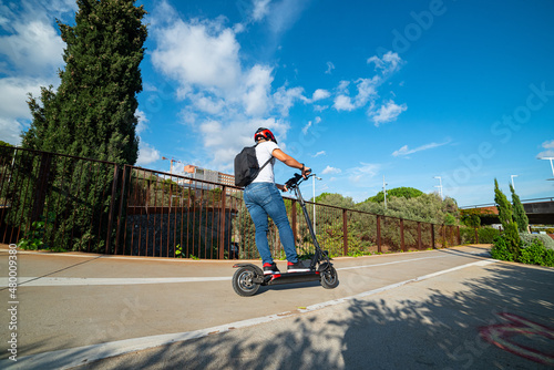 A boy riding his scooter along the bike lane in the city of Barcelona