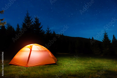 Illuminated tent in night forest © Pavlo Vakhrushev