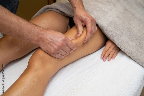 Woman getting legs lymphatic drainage massage in spa salon. Closeup. Body relaxation beauty and body care concept.