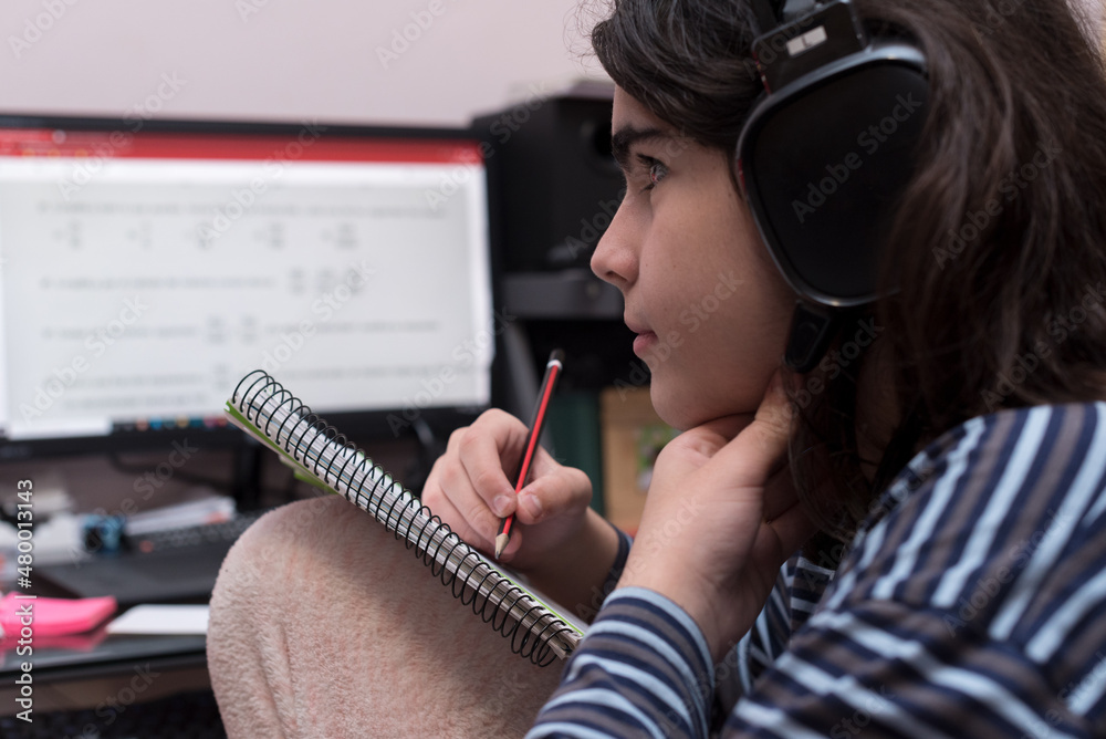Transgender teenager with headphones and microphone studying in front ...