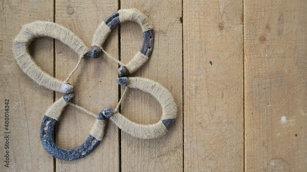 DIY handmade trefoil clover from horseshoes for your daily luck on a wooden background 
