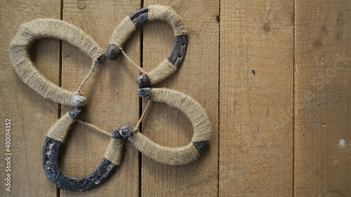 DIY handmade trefoil clover from horseshoes for your daily luck on a wooden background 