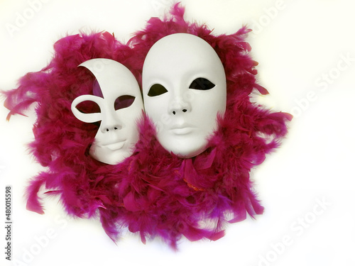 Fototapeta Naklejka Na Ścianę i Meble -  two carnival Venetian masks, faces laying in pink feathers, white background