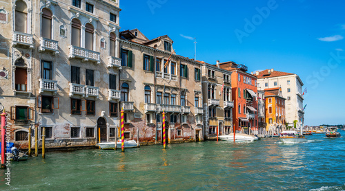 Colorful facades of old medieval houses in Venice, Italy. View on canal with boats and motorboats. Picturesque landscape. Retro vintage Instagram style filter effect.