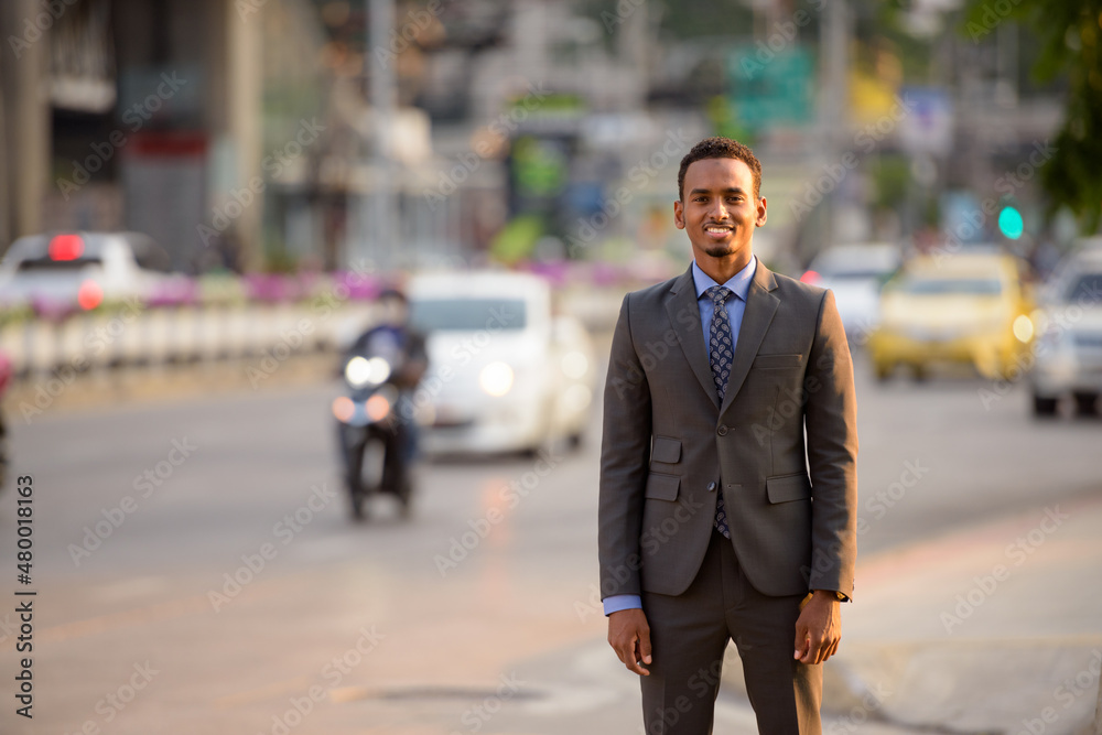 Handsome young black businessman wearing suit in city street Handsome young black businessman wearing suit in city street