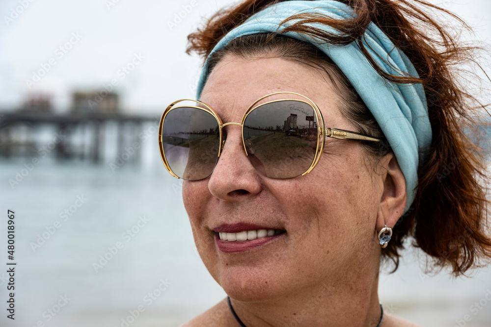 beautiful woman over 50 in sunglasses relaxing on the beach in Ecuador beautiful woman over 50 in sunglasses relaxing on the beach in Ecuador