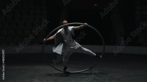 Circus artist Rotates on the wheel of Syrah in the arena. A large hoop rotates together with a person.