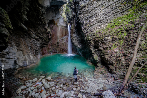 Men, backpacker standing in front of waterfall Kozjak in Triglav National Park, Slovenia