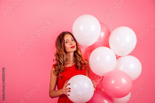 Beautiful girl colored with balloons on a pink background. 